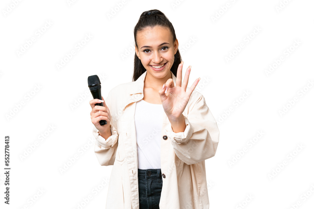 Young singer woman picking up a microphone over isolated chroma key background happy and counting three with fingers Young singer woman picking up a microphone over isolated chroma key background happy and counting three with fingers