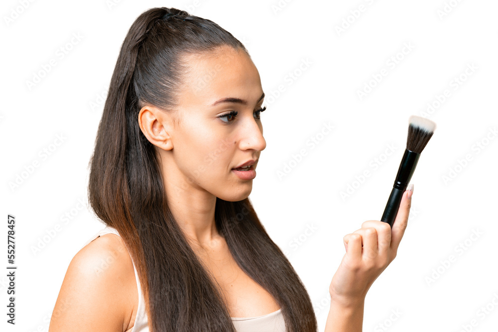 Young Arabian woman over isolated chroma key background holding makeup brush Young Arabian woman over isolated chroma key background holding makeup brush