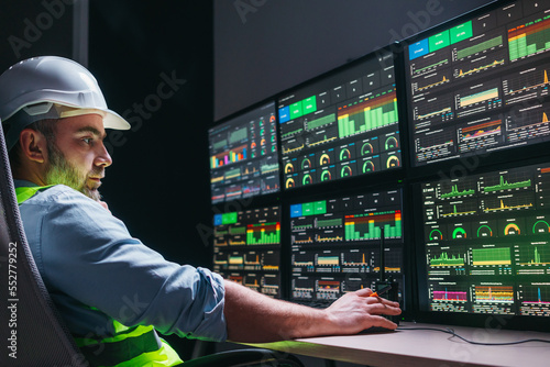 Industry 4.0. Head engineer control production line with computer screens. Factory operator following assembly process uses human-machine interface