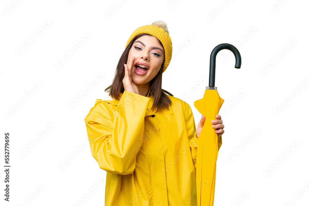 Young Russian woman with rainproof coat and umbrella over isolated chroma key background shouting with mouth wide open Young Russian woman with rainproof coat and umbrella over isolated chroma key background shouting with mouth wide open