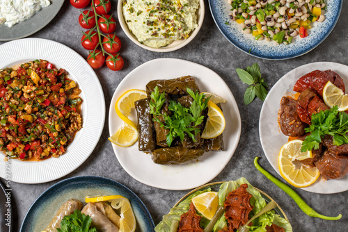 Top view traditional Turkish and Greek dinner appetizer table. Mediterranean appetizer concept. Raw meatballs, roasted eggplant salad, stuffed olives, stuffed peppers, gavurdagi salad