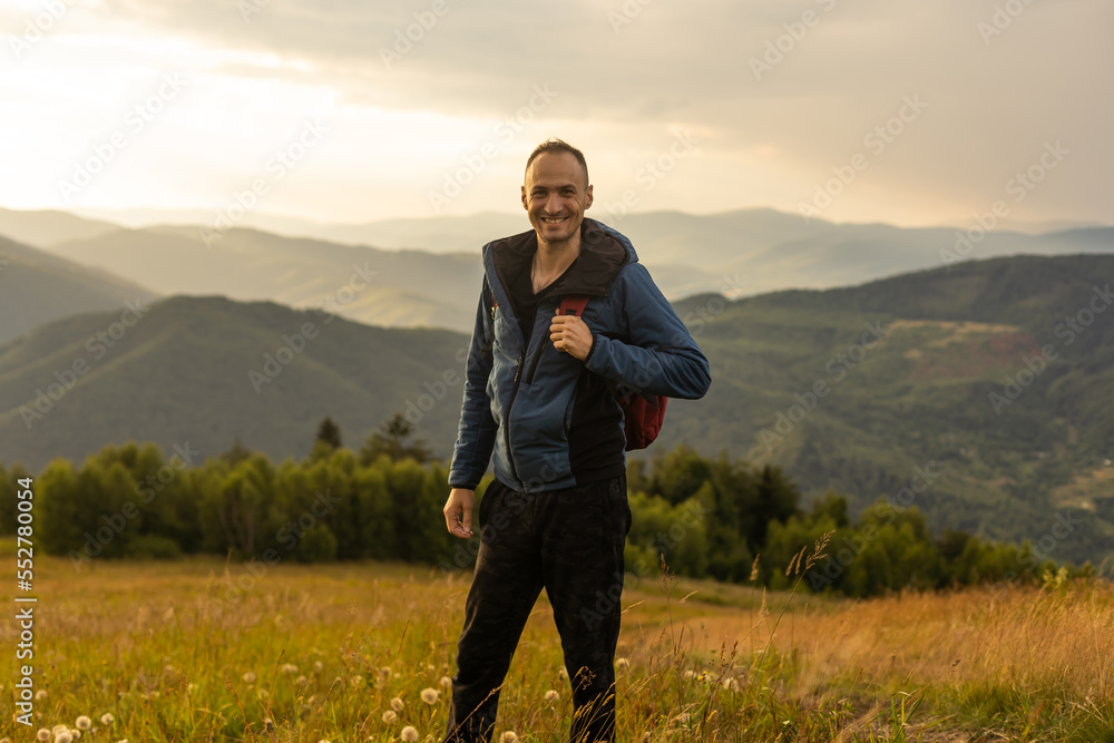 Young man enjoying the view on the top of the mountain. Carpathian mountains, Ukraine