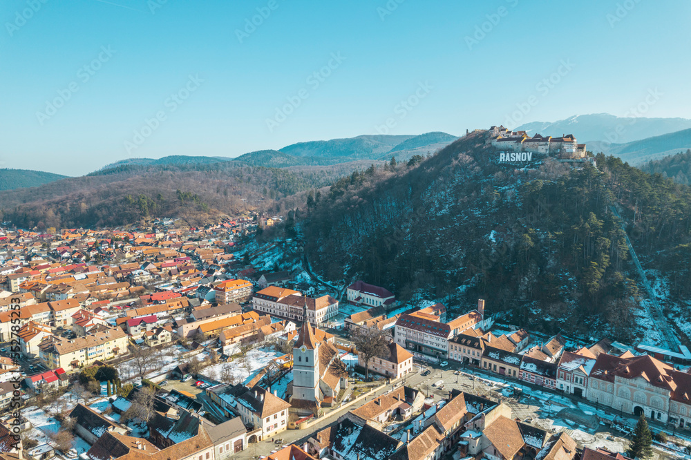Aerial view of Rasnov fortress near Brasov, Transylvania, Romania. Rasnov Citadel and Fortress on the top of the hill in Transylvania. Drone shot of Rasnov Medieval city