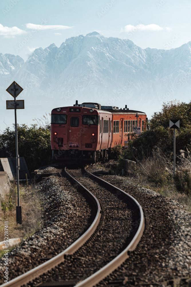 Obraz premium S字カーブを曲がる列車とバックに立山連峰