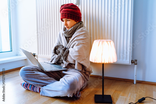 Frozen teenager near battery in cold house studying online