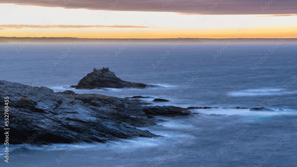 Dramatic landscape sunrise image at Prussia Cove in Cornwall England with atmospheric sky and ocean