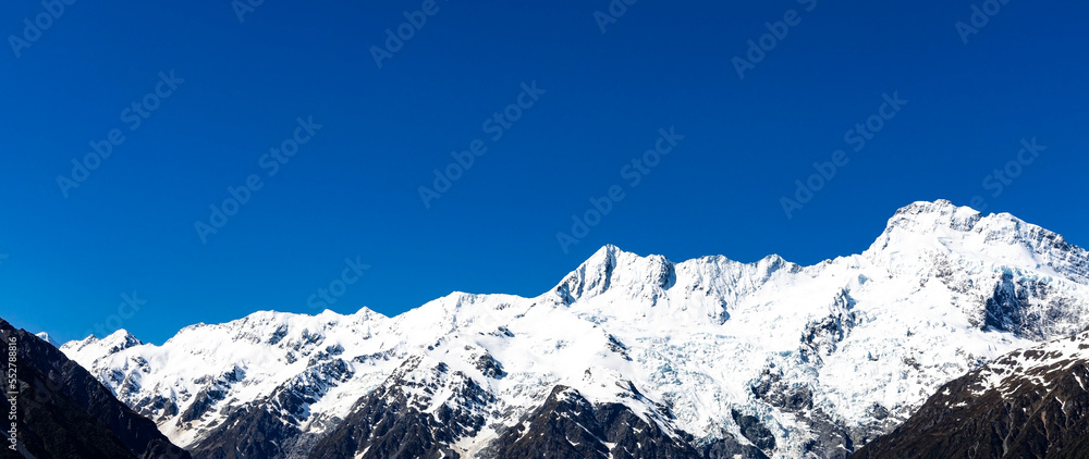 The mountain view of alpine as snow-capped mount peaks in  Swiss Mountain alps against the blue sky background