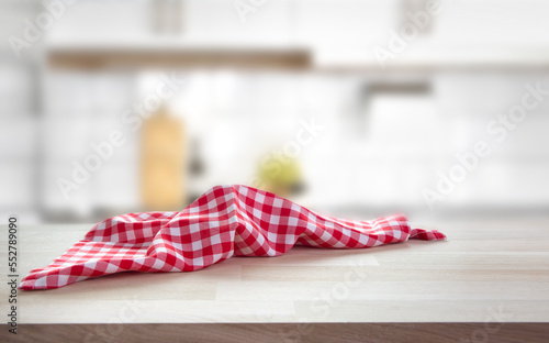 Checkered towel on wooden table blurred kitchen background. Picnic cloth empty space. Tabletop.