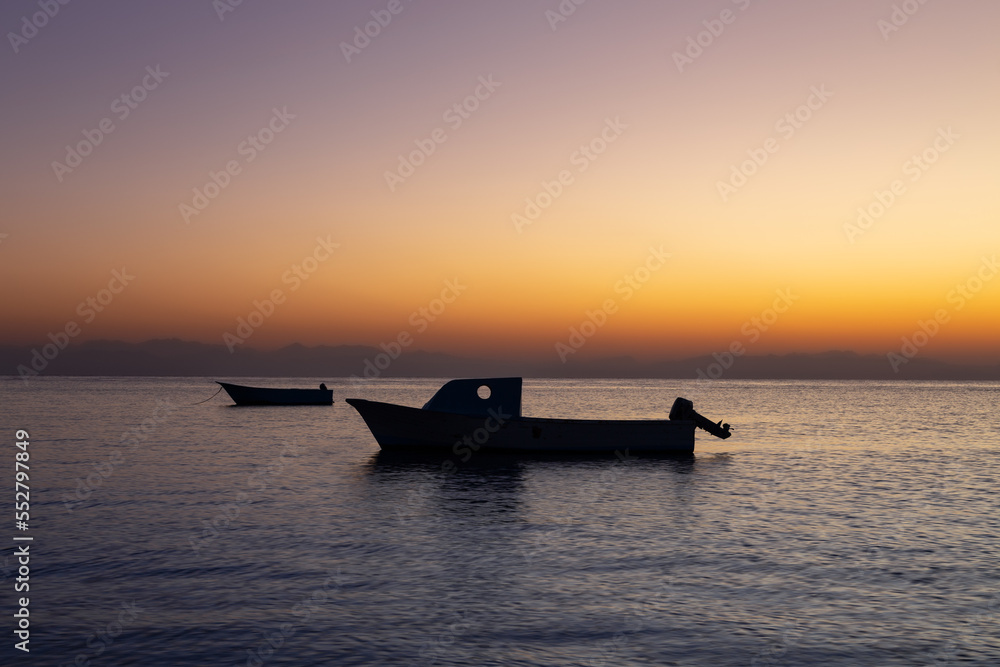 Colorful sunrise seascape with fisherman boats in the foreground, Dahab, Sinai, Egypt