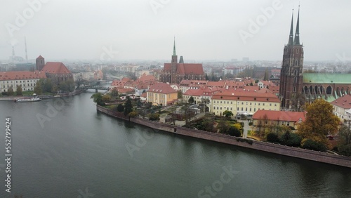 Aerial view of Odra river in Wroclaw with old church, bridge and old town covered by foggy whether