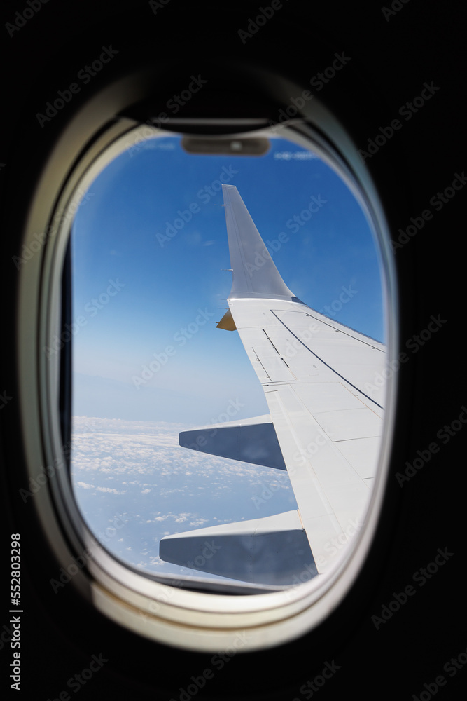 View from Inside an Aircraft: Window of the Cabin, White Airplane Wing and Clouds View from Inside an Aircraft: Window of the Cabin, White Airplane Wing and Clouds