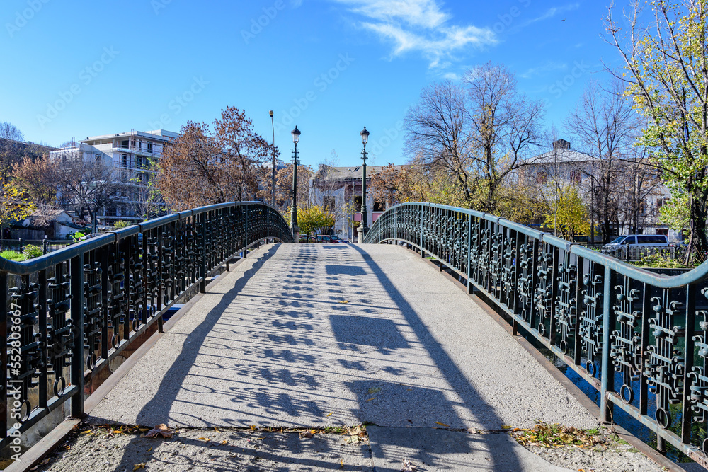 Old green metallic rusted bridge over Dambovita river in Bucharest, Romania, in a sunny autumn day