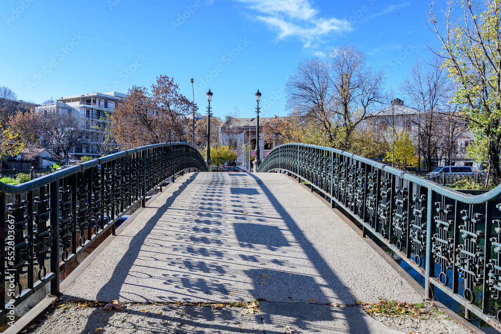 Fototapeta premium Old green metallic rusted bridge over Dambovita river in Bucharest, Romania, in a sunny autumn day