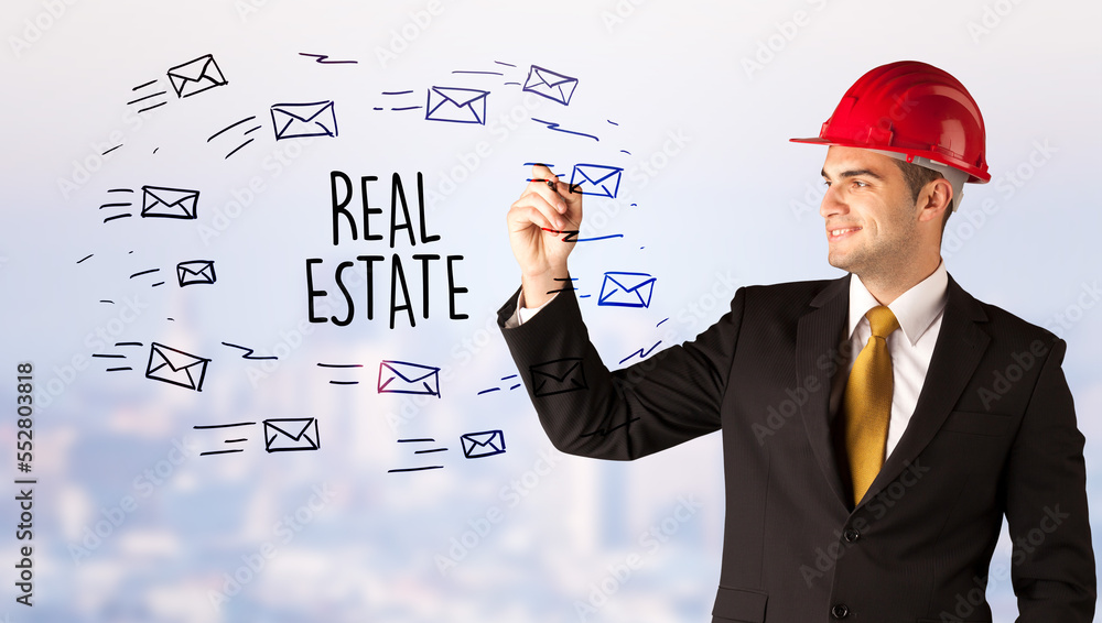 Young businessman with helmet drawing sale sign Young businessman with helmet drawing sale sign