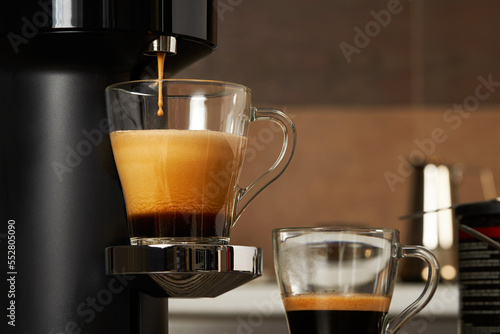 Closeup of a glass cup with fresh coffee from a capsule coffee machine photo