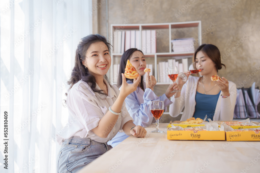 Smile and looking camera, Group of young asian office girl friends having fun and celebrating pizza on table during party Smile and looking camera, Group of young asian office girl friends having fun and celebrating pizza on table during party