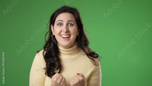 Great success winner portrait of pretty young 20s woman getting isolated over green screen background in studio. People sincere emotions, lifestyle concept. Looking at the camera © Robert Peak