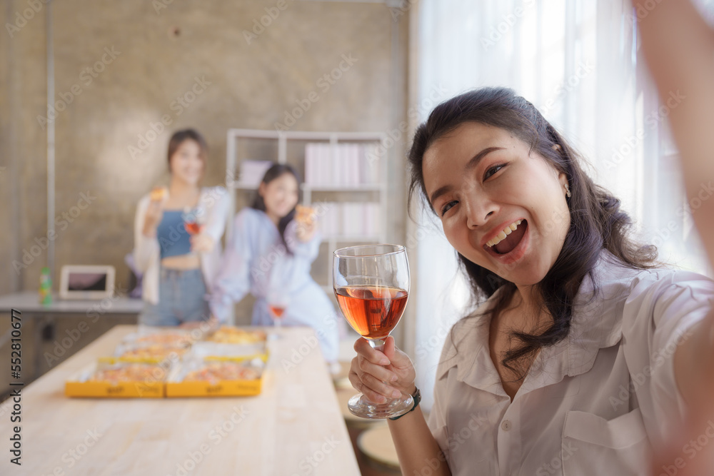 Selfie shot, Group of young asian office girl friends having fun and celebrating pizza on table during party Selfie shot, Group of young asian office girl friends having fun and celebrating pizza on table during party