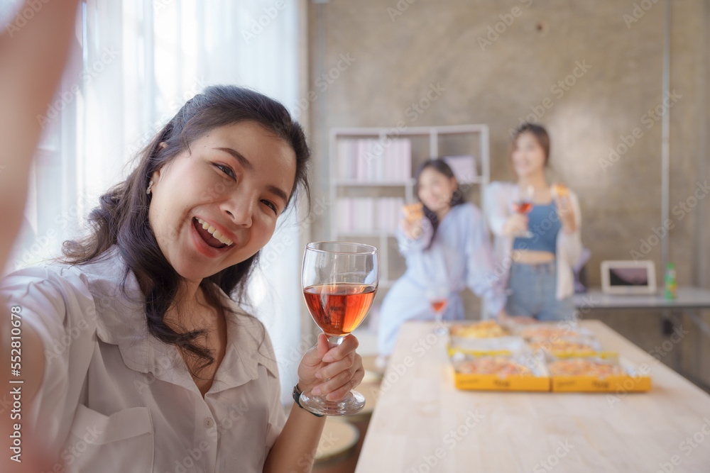 Selfie shot, Group of young asian office girl friends having fun and celebrating pizza on table during party Selfie shot, Group of young asian office girl friends having fun and celebrating pizza on table during party