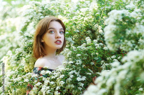 Obraz na płótnie Young beautiful girl on a summer day among flowering trees w salonie