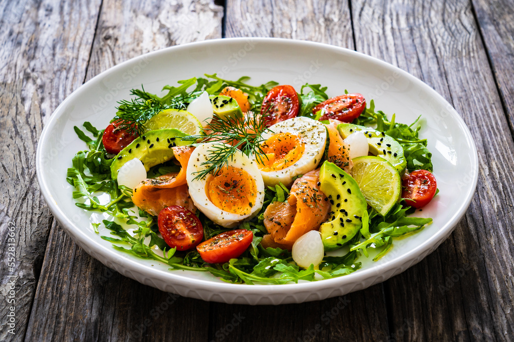 Salmon salad - smoked salmon, hard boiled eggs, avocado and leafy greens on wooden table
Salmon salad - smoked salmon, hard boiled eggs, avocado and leafy greens on wooden table