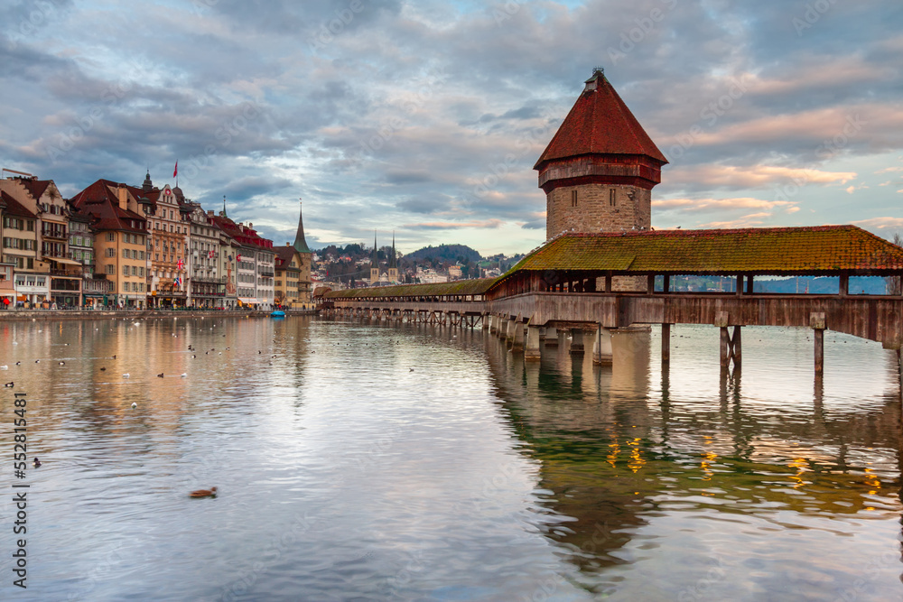 Ctyscape Lucerne Switzerland. Chapel Bridge across lake Lucerne with the Jesuit church on the banks of the lake. Landscape of amazing travel destination.