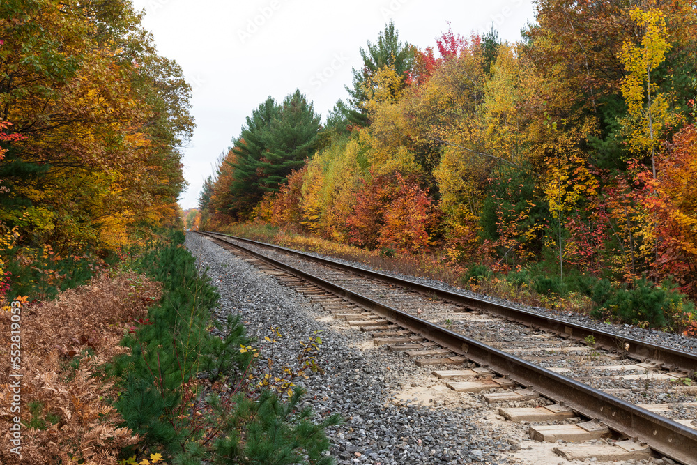 Sainte Ursule, Canada, 10-12-2022. Railway with fall colors in background near Sainte Ursule Waterfall. Canada. Sainte Ursule, Canada, 10-12-2022. Railway with fall colors in background near Sainte Ursule Waterfall. Canada.