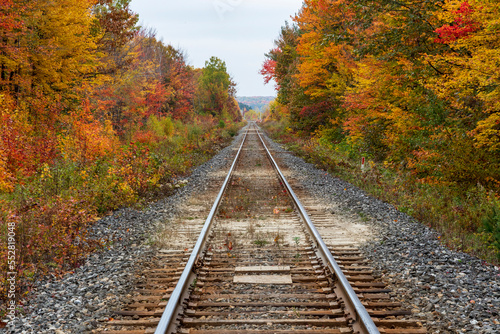 Sainte Ursule, Canada, 10-12-2022. Railway with fall colors in background near Sainte Ursule Waterfall. Canada.