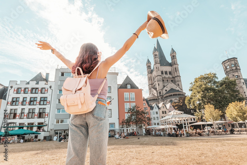 Happy tourist girl walks and enjoys vacations in the old town of Cologne at fish market square. Germany travel and sightseeing photo