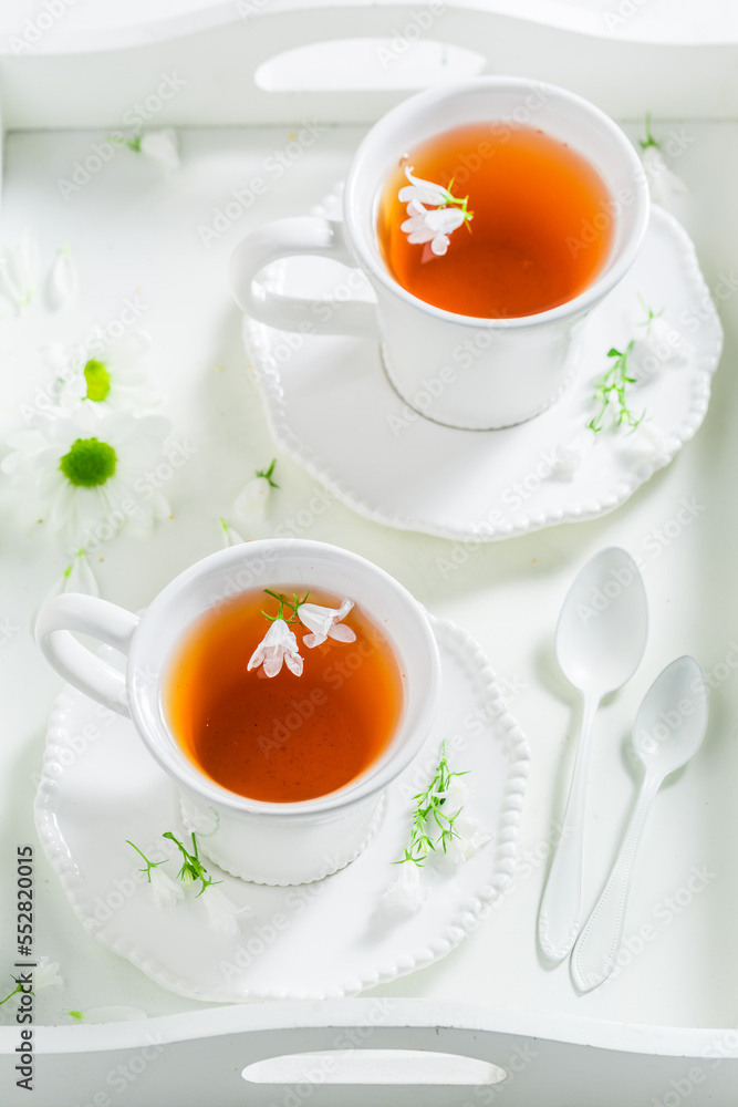 Two cups of tea served on white tray with flowers. Two cups of tea served on white tray with flowers.