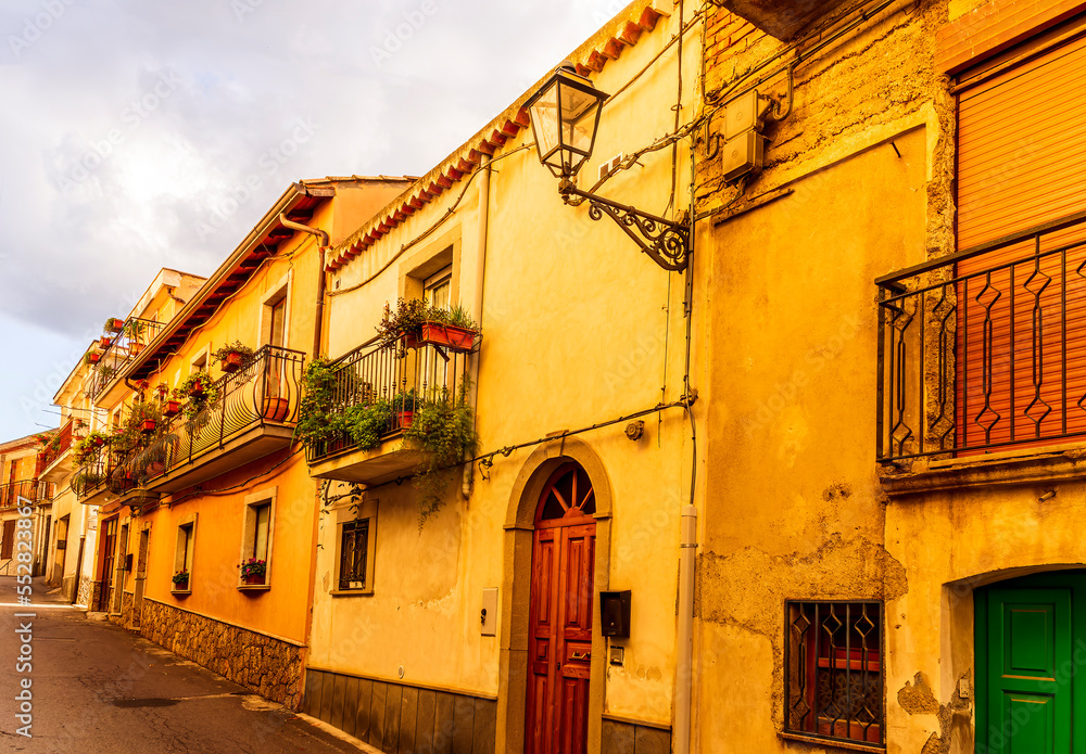 old mediterranean mountain dense town with yellow houses in evening light, vintage european village