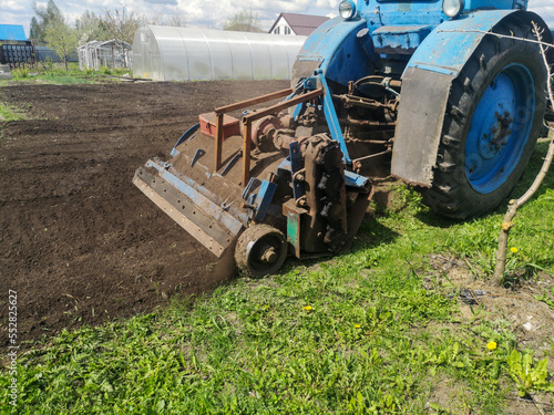 The tractor plows the soil on the field
