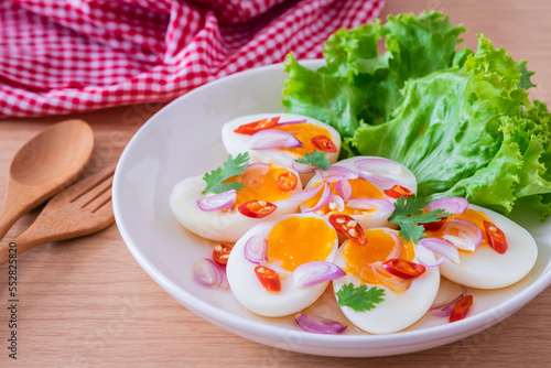 Spicy boiled eggs salad on white plate.