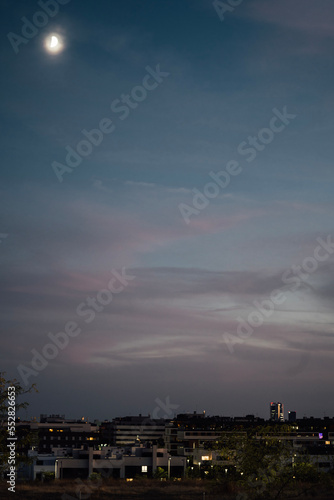 Skyline of Alcobendas with Madrid city center in the background at night. sky clouds moon copy space photo