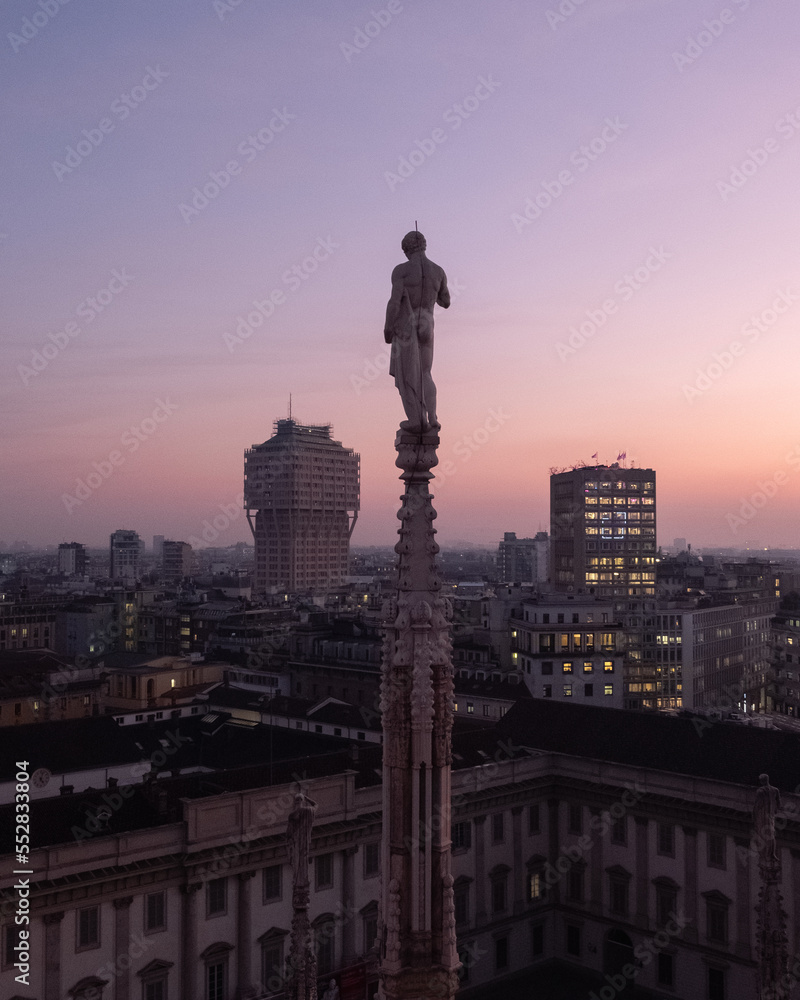 Duomo statue at dusk looking at the city