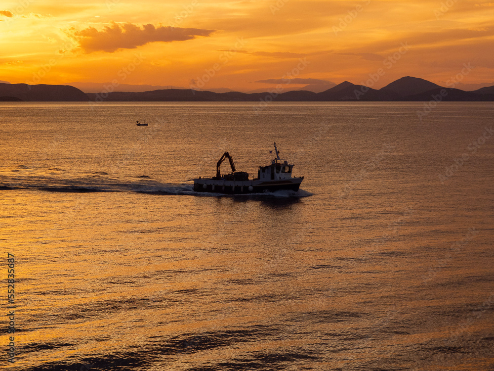 Naklejka premium fishing boat at sunset