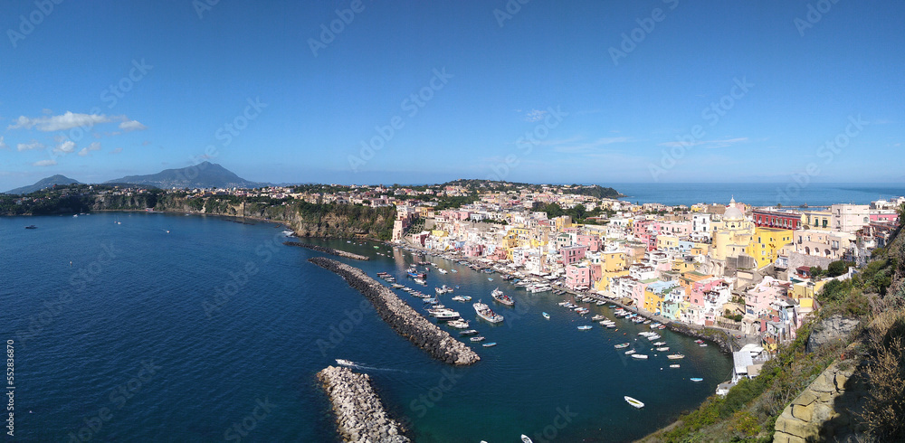 Colorful view of the Village of Marina di Corricella in the Island of Procida and view of the Island of Ischia in the rear. Campania. Italy.