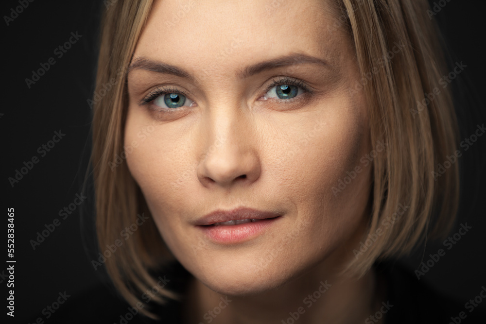 Beautiful middle-aged woman on a gray background in a black blouse. Beautiful middle-aged woman on a gray background in a black blouse.