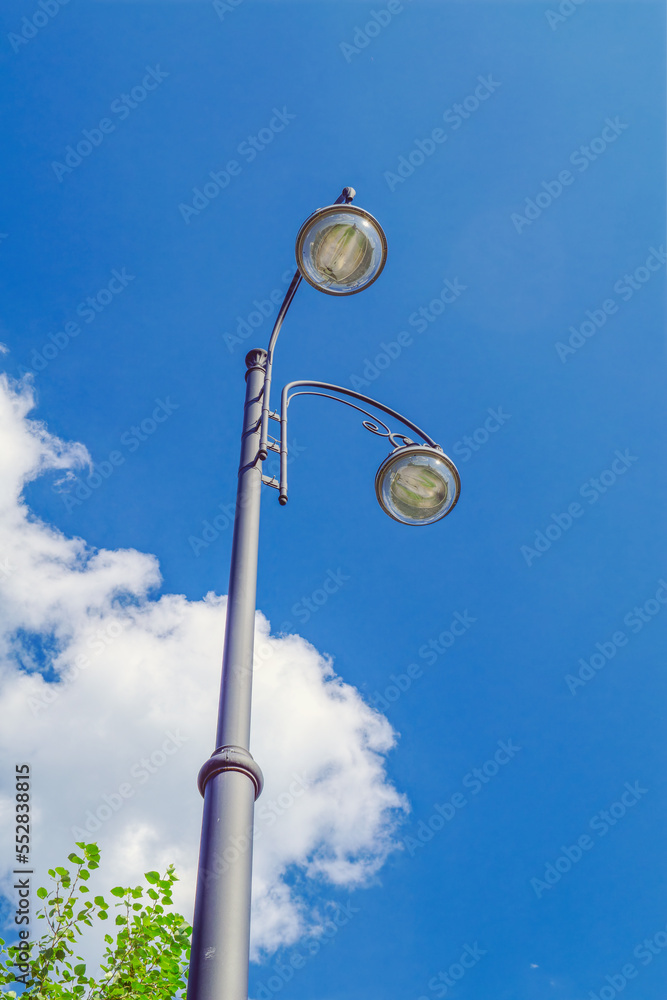 Street lamp close-up against the blue sky in summer. Street lamp close-up against the blue sky in summer.