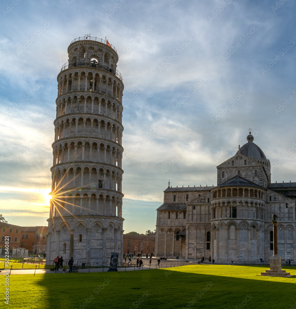 the Leaning Tower of Pisa and the Cathedral in warm evening light with a sunburst