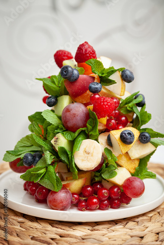 Closeup Christmas tree made of fruits and mint leaves. Celebration, festive season and winter concept
