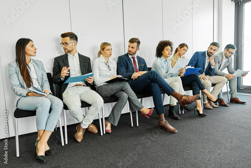 man business chair sitting waiting businessman candidate recruitment office businesswoman woman businessperson job young interview line employee career row hall colleague