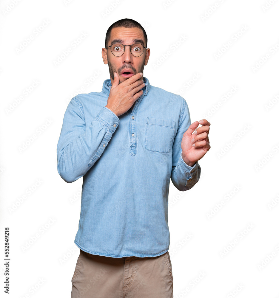 Astonished young man with a gesture of shock Astonished young man with a gesture of shock