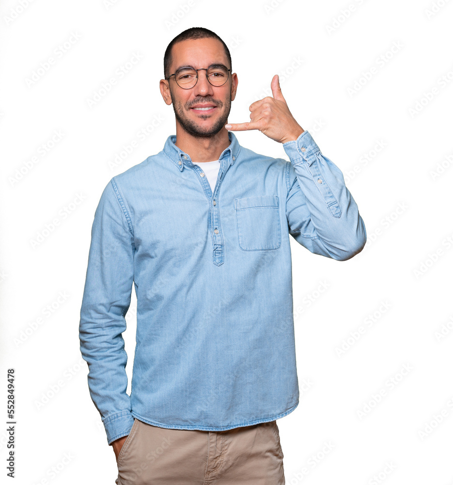 Happy young man making a gesture of calling with the hand Happy young man making a gesture of calling with the hand