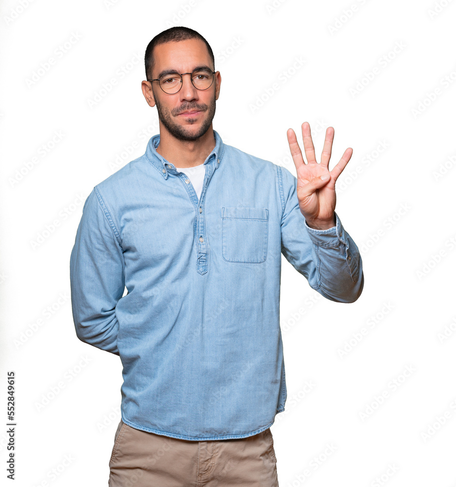 Young man making a number four gesture Young man making a number four gesture