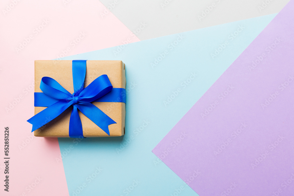 holiday handmade paper present tied blue ribbon bow top view with copy space. Flat lay holiday background. Birthday or christmas present. Christmas gift box concept with copy space