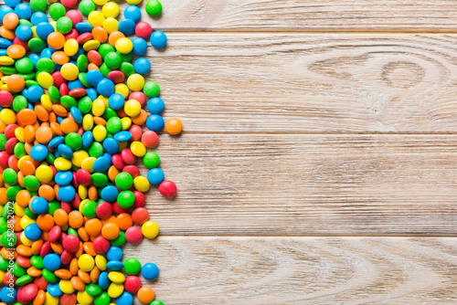 Mixed collection of colorful candy, on colored background. Flat lay, top view. frame of colorful chocolate coated candy