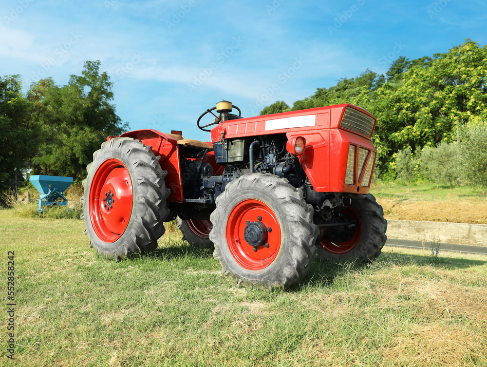 Modern tractor in mowed field on sunny day. Agricultural industry Modern tractor in mowed field on sunny day. Agricultural industry