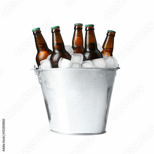 Metal bucket with bottles of beer and ice cubes on white background