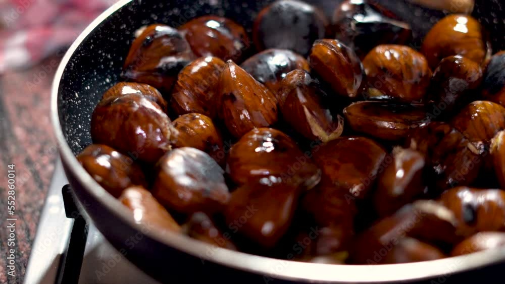 One person roasting chestnuts on a pan One person roasting chestnuts on a pan